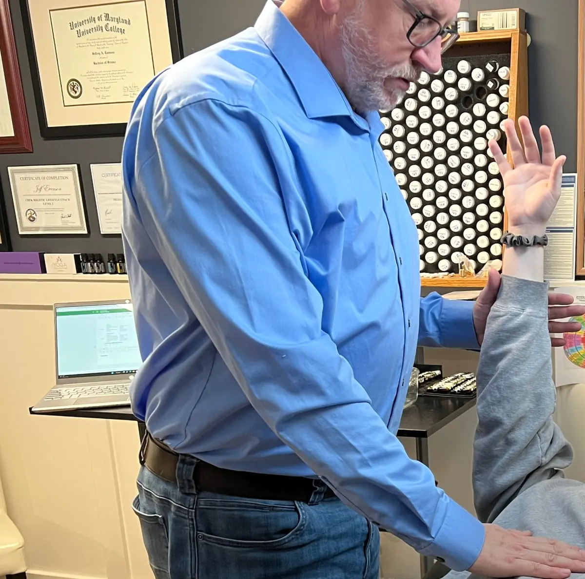 Jeff muscle testing a client's raised arm in his session room